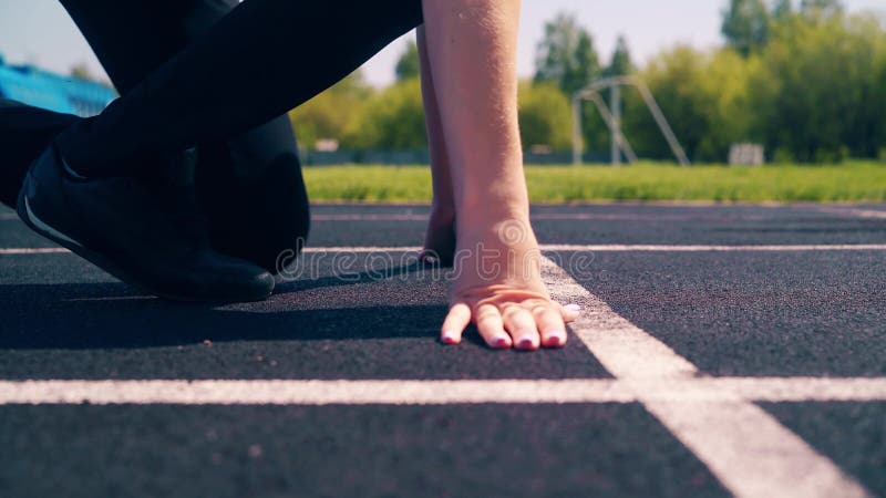 CU, tiro lateral: Muchacha linda joven, constitución deportiva, en el estadio Ella va a la línea del comienzo