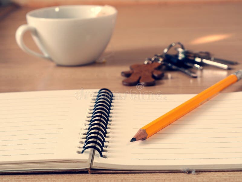 Cuaderno y lápiz con una taza de fondo del té foto de archivo Cuaderno y lápiz con una taza de fondo del té foto de archivo