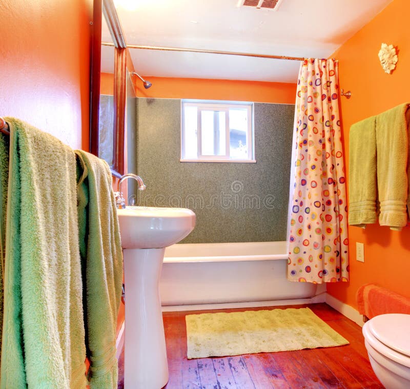 Cuarto de baño anaranjado y verde con el suelo de la tina y de madera. foto de archivo Cuarto de baño anaranjado y verde con el suelo de la tina y de madera. foto de archivo