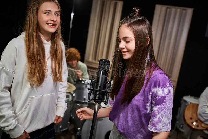 four adorable jolly teens singing and playing various instruments in studio, musical group, stock photo. four adorable jolly teens singing and playing various instruments in studio, musical group, stock photo