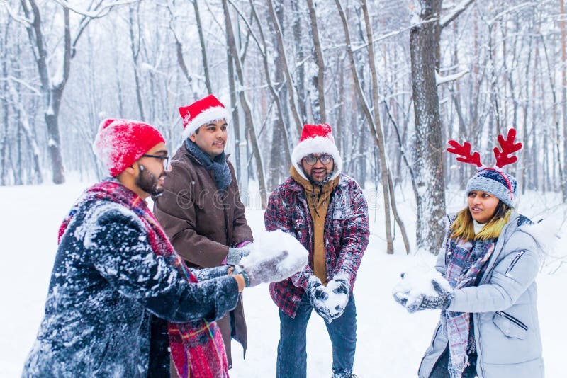 Cuatro amigos felices se están divirtiendo y tirando nieve imagen de archivo libre de regalías