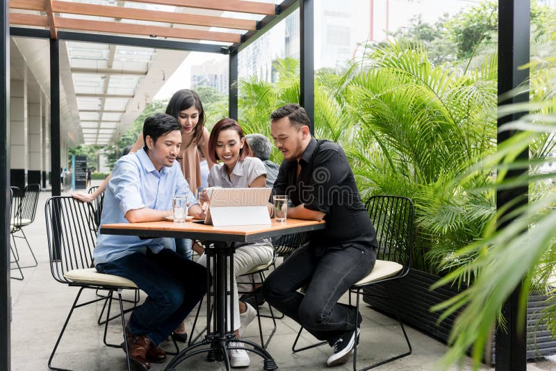Cuatro amigos jovenes asiáticos que sonríen mientras que mira junto o divertido foto de archivo Cuatro amigos jovenes asiáticos que sonríen mientras que mira junto o divertido foto de archivo