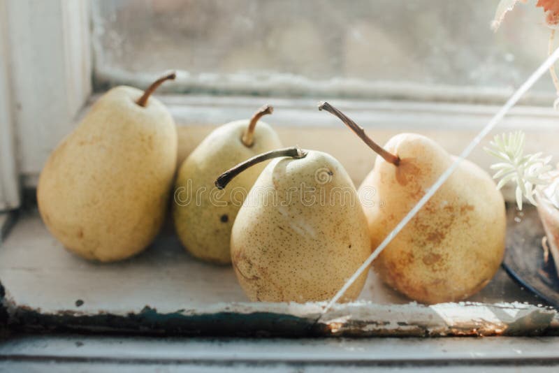 Cuatro peras maduras en la ventana de la cocina imágenes de archivo libres de regalías Cuatro peras maduras en la ventana de la cocina imágenes de archivo libres de regalías