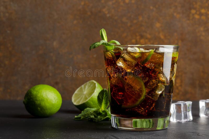 Cuba Libre, Rum and Cola Cocktail in Glass with a Lime and Mint on