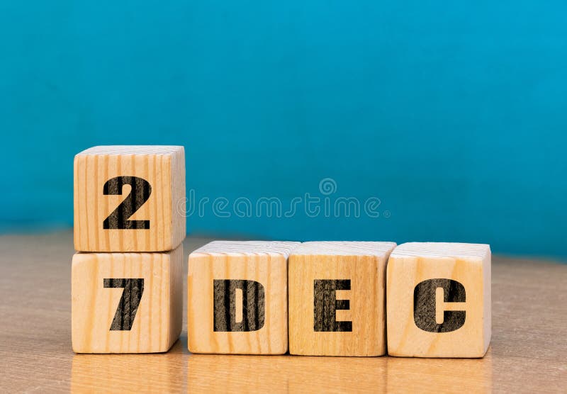 Cube shape calendar for December 27 on wooden surface with empty space for text stock photos