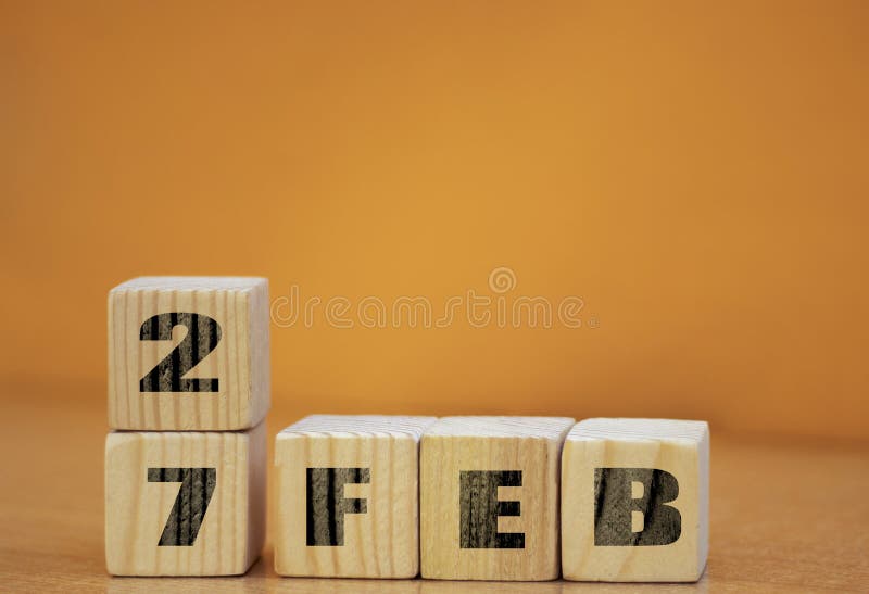 Cube shape calendar for february 27 on wooden surface with empty space for text, new year Wooden calendar with date, February cube royalty free stock photo