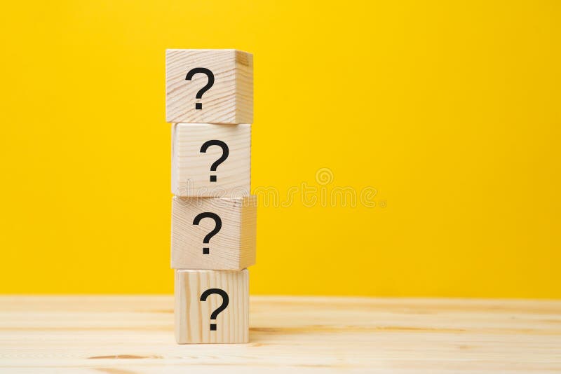 Cubes with question marks on a yellow background  close-up. Space for the text. Wooden cubes. Cubes with question marks on a yellow background  close-up. Space for the text. Wooden cubes