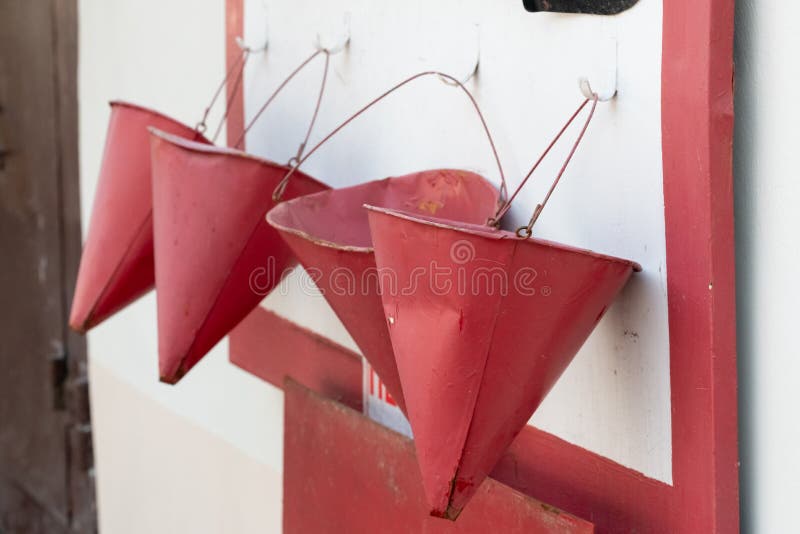 cubeta vermelha para lutar o fogo uma cubeta vermelha está pendurando em um protetor do fogo foto de stock cubeta vermelha para lutar o fogo uma cubeta vermelha está pendurando em um protetor do fogo foto de stock