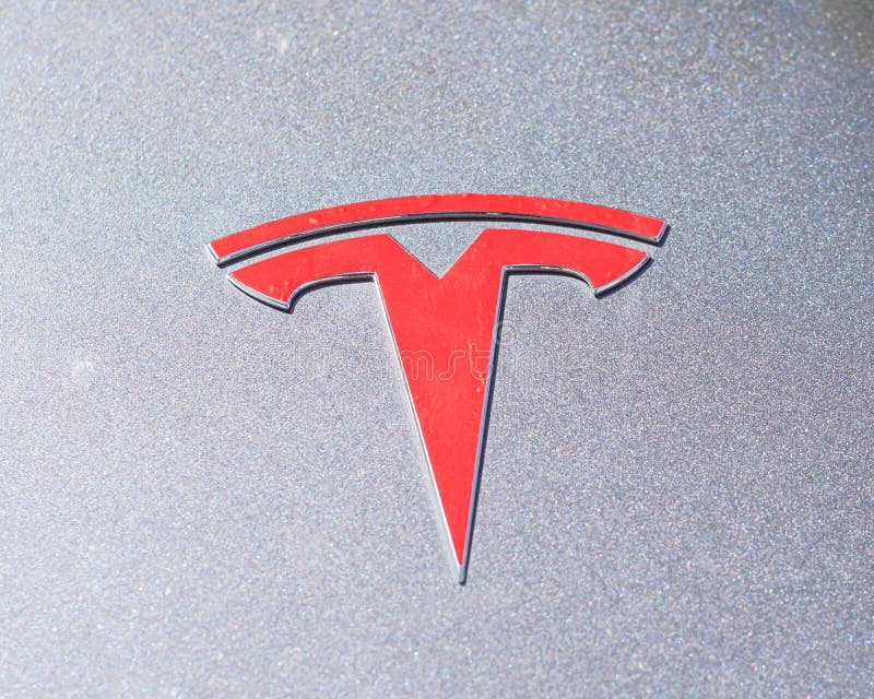 Cubierta de plata de la capilla del coche con el primer del logotipo de Tesla foto de archivo Cubierta de plata de la capilla del coche con el primer del logotipo de Tesla foto de archivo