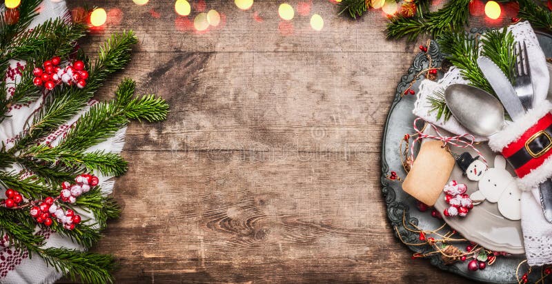 Cubierto de la tabla de la Navidad con la decoración festiva, la placa, los cubiertos, el muñeco de nieve hecho a mano y la etiqu