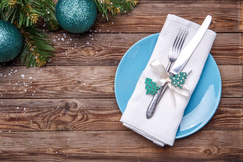 Cubierto de la tabla de la Navidad con la placa azul, bifurcación y cuchillo, cinta adornada y arco con el juguete del abeto, ser imágenes de archivo libres de regalías Cubierto de la tabla de la Navidad con la placa azul, bifurcación y cuchillo, cinta adornada y arco con el juguete del abeto, ser imágenes de archivo libres de regalías