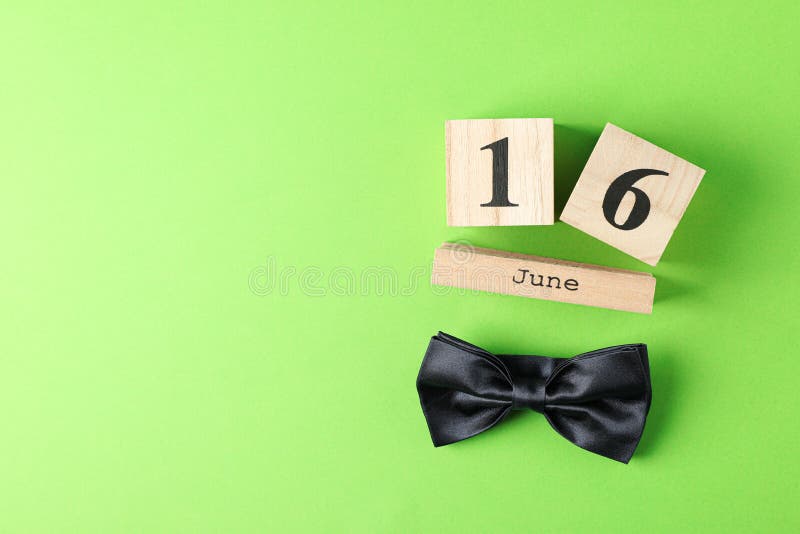 Cubos calendário data o 16 de junho e laço de madeira no fundo da cor imagens de stock Cubos calendário data o 16 de junho e laço de madeira no fundo da cor imagens de stock