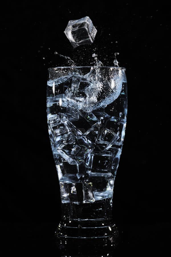 Cubos de hielo que salpican en vidrio imagenes de archivo Cubos de hielo que salpican en vidrio imagenes de archivo