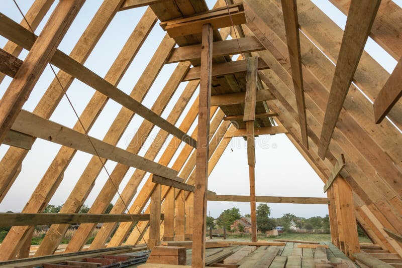Cubra la estructura del marco en el hogar de madera del marco bajo construcción en la puesta del sol fotos de archivo libres de regalías Cubra la estructura del marco en el hogar de madera del marco bajo construcción en la puesta del sol fotos de archivo libres de regalías