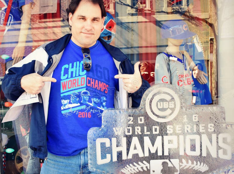 A Chicago Cubs fan proudly wears his World Series Champion shirt next to a 2016 Cubs World Champions Ice Sculpture in front of a sporting goods store in Downtown Kenosha, Wisconsin for Snow Daze.