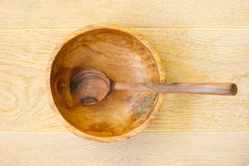 Cucchiaio di legno in una ciotola di legno immagini stock libere da diritti Cucchiaio di legno in una ciotola di legno immagini stock libere da diritti