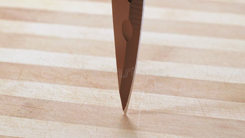 Cuchilla de cocina girando sobre mesa de madera cerca de tiro. fondo abstracto de borde de cuchillo afilado. textura de madera metrajes
