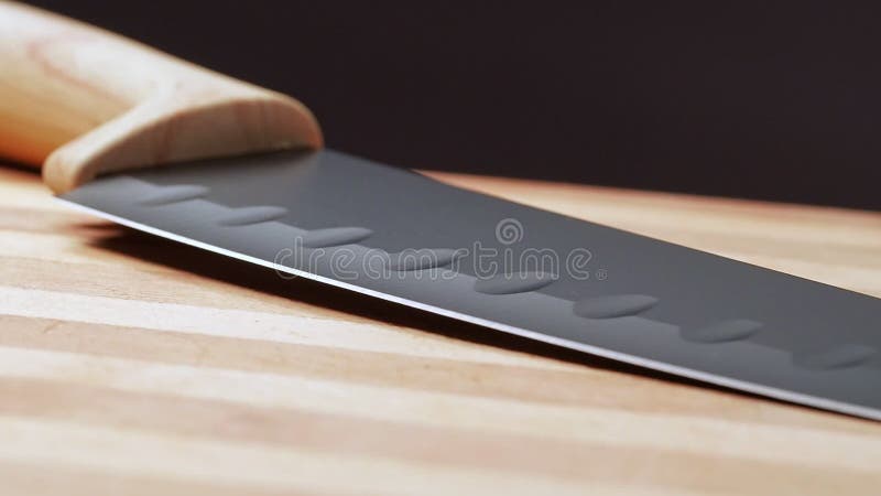 Cuchillo con mango de madera sobre la mesa en la cocina, tiro de cerca Cámara que se mueve de la manecilla a punto de punto de co almacen de metraje de vídeo