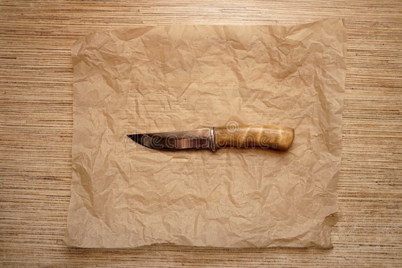 Cuchillo de caza en el papel arrugado foto de archivo libre de regalías Cuchillo de caza en el papel arrugado foto de archivo libre de regalías