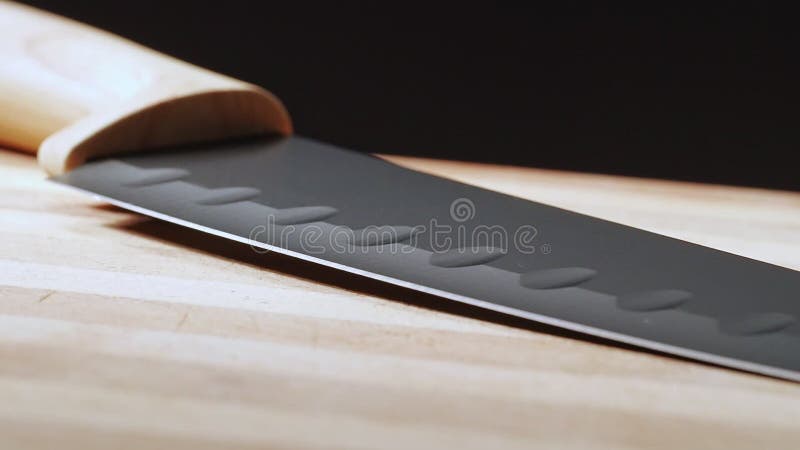 Cuchillo de cocina sobre un escritorio de madera, tiro cerrado Cámara pasando de punto de contacto a manipular Cuadros en hoja os almacen de metraje de vídeo