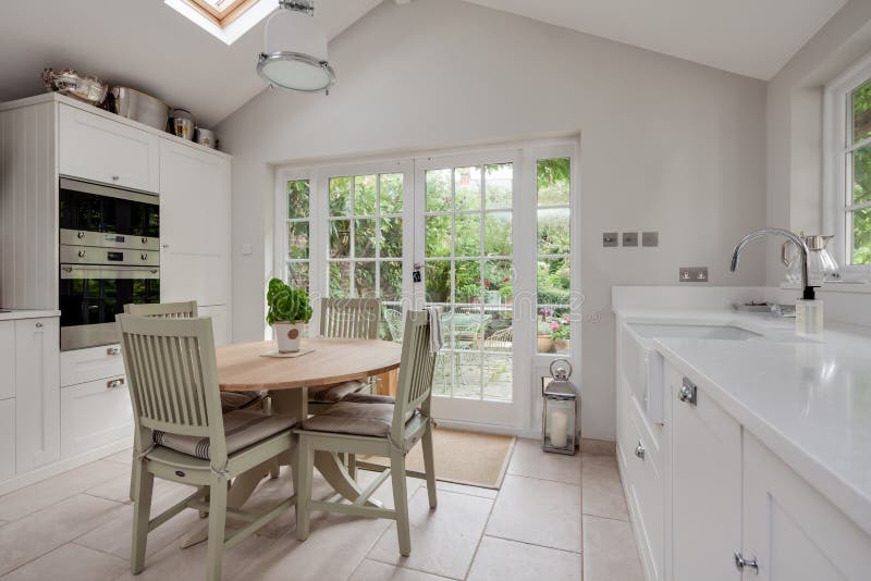 Saffron Walden, Essex, England - Sept 4 2018: Furnished luxury fitted cottage kitchen with sloping ceiling, table and chairs. Saffron Walden, Essex, England - Sept 4 2018: Furnished luxury fitted cottage kitchen with sloping ceiling, table and chairs