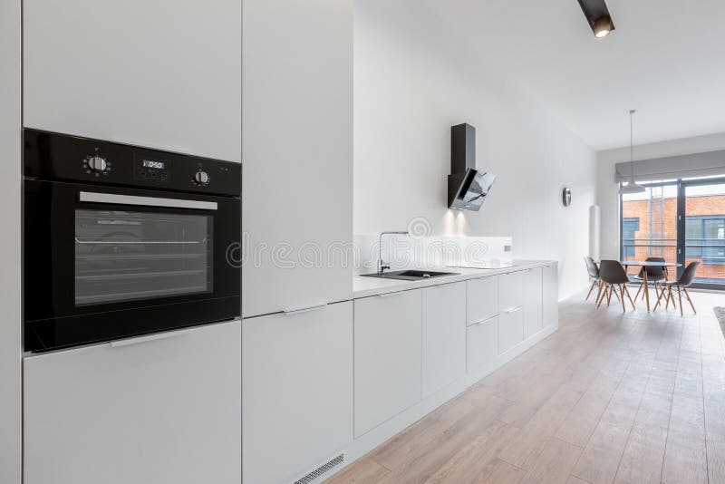 Cucina bianca spessa con pavimento di legno fotografia stock