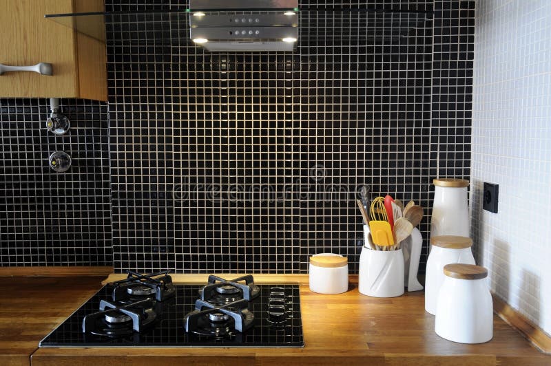 Cucina con le mattonelle nere lustrate ed il contatore di legno fotografia stock libera da diritti Cucina con le mattonelle nere lustrate ed il contatore di legno fotografia stock libera da diritti