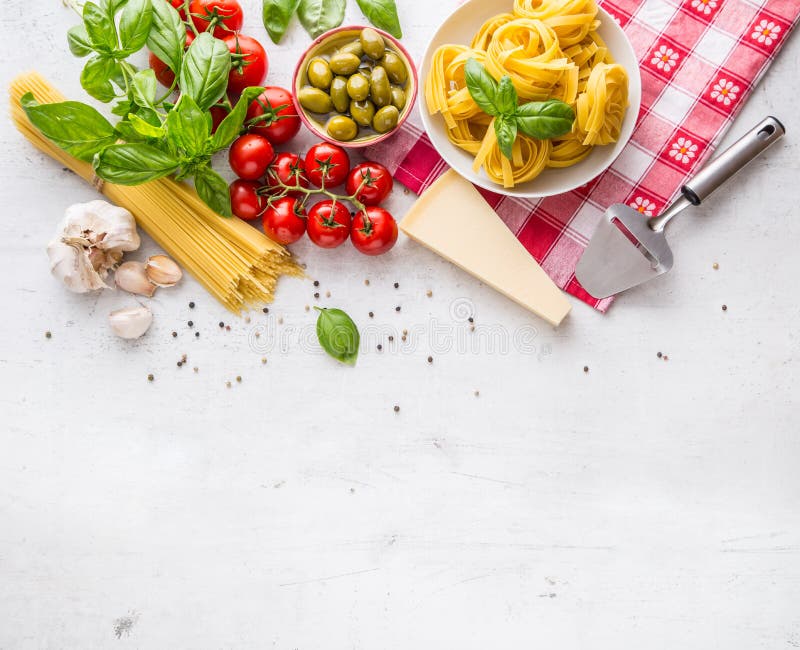 Cucina italiana ed ingredienti dell'alimento sulla tavola concreta bianca Parmigiano dei pomodori dell'olio d'oliva delle olive d