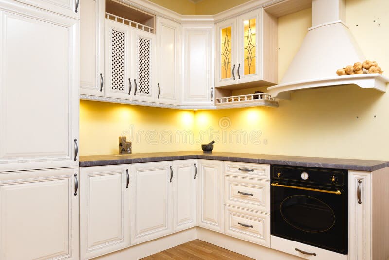 Cucina vuota bianca con mobilia bianca leggera - luci calde e legno piacevolmente decorato fotografia stock Cucina vuota bianca con mobilia bianca leggera - luci calde e legno piacevolmente decorato fotografia stock