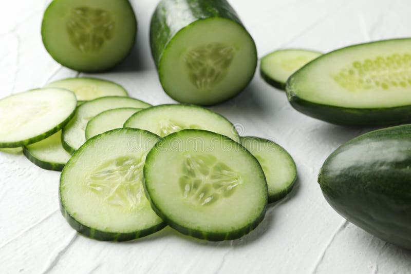 Cucumbers and slices on white background