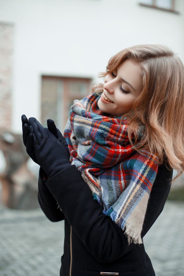 Cudowna atrakcyjna młoda kobieta w eleganckim czarnym żakiecie z woolen ciepłym szalikiem w czarnych rękawiczek pozach na uliczny zdjęcie royalty free Cudowna atrakcyjna młoda kobieta w eleganckim czarnym żakiecie z woolen ciepłym szalikiem w czarnych rękawiczek pozach na uliczny zdjęcie royalty free