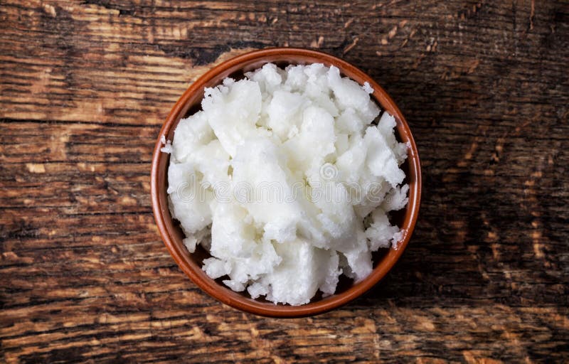 Bowl of coconut oil on wooden table, top view. Bowl of coconut oil on wooden table, top view