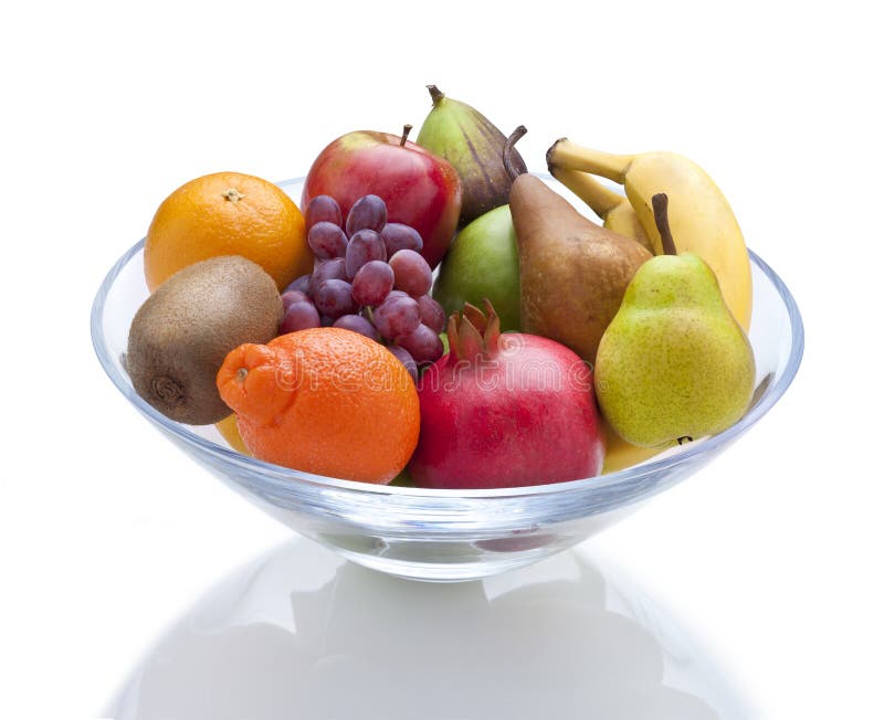 A glass bowl of fruit on a white background with a reflection. A glass bowl of fruit on a white background with a reflection