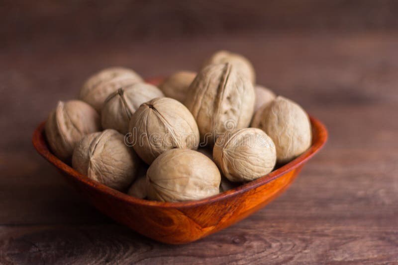 Cuenco lleno de nueces en fondo de madera fotografía de archivo libre de regalías Cuenco lleno de nueces en fondo de madera fotografía de archivo libre de regalías