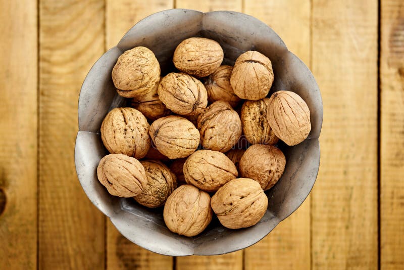 Cuenco por completo de nueces deliciosas y frescas en la tabla de madera fotos de archivo Cuenco por completo de nueces deliciosas y frescas en la tabla de madera fotos de archivo