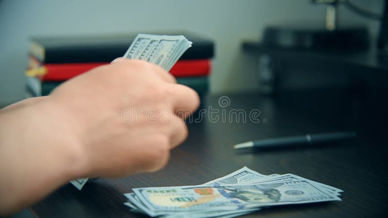 Cuenta de dólares de mano de hombre de negocios en escritorio.