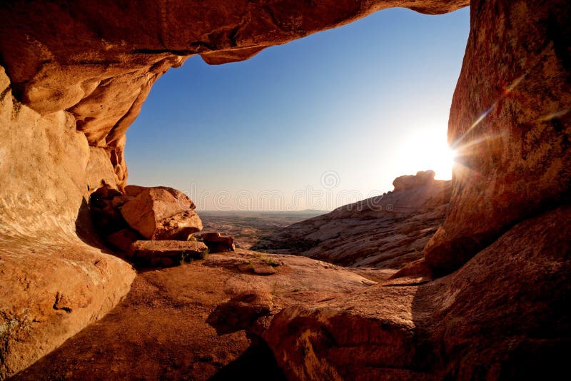 Cueva y puesta del sol en las montañas del desierto