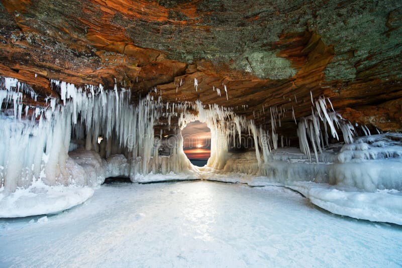 Cuevas de hielo en las islas del apóstol, puesta del sol del invierno