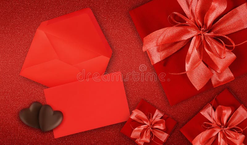 Cufere cu card cadou de o zi Valentin cu panglică roșie lucioasă, cu funvă în formă de fundal roșu, cu spațiu pentru copii royalty free stock image