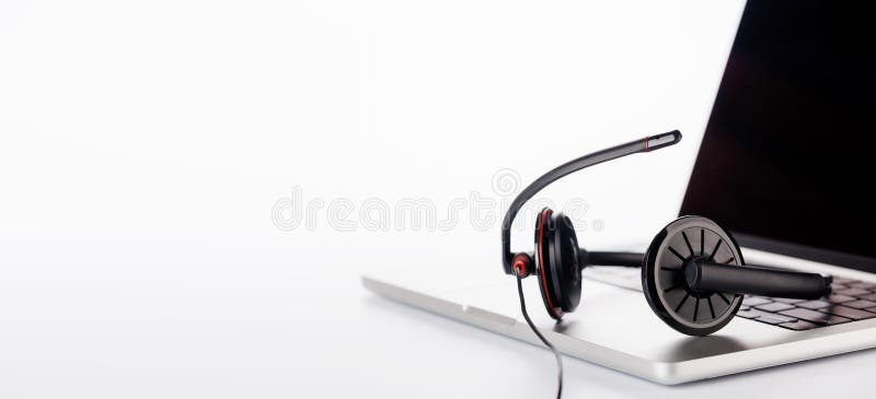 Cuffie eleganti poggiate su un laptop impostato su uno sfondo bianco luminoso immagine stock libera da diritti