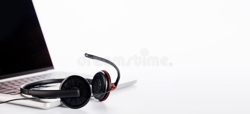 Cuffie eleganti poggiate su un laptop impostato su uno sfondo bianco luminoso fotografia stock