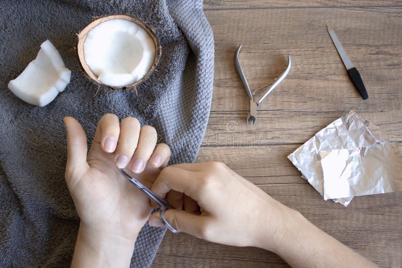 Cuidado da mão, cuidado popular da mão Tratamento de mãos com óleo de coco, ferramentas do tratamento de mãos: tesouras, arquivo foto de stock Cuidado da mão, cuidado popular da mão Tratamento de mãos com óleo de coco, ferramentas do tratamento de mãos: tesouras, arquivo foto de stock