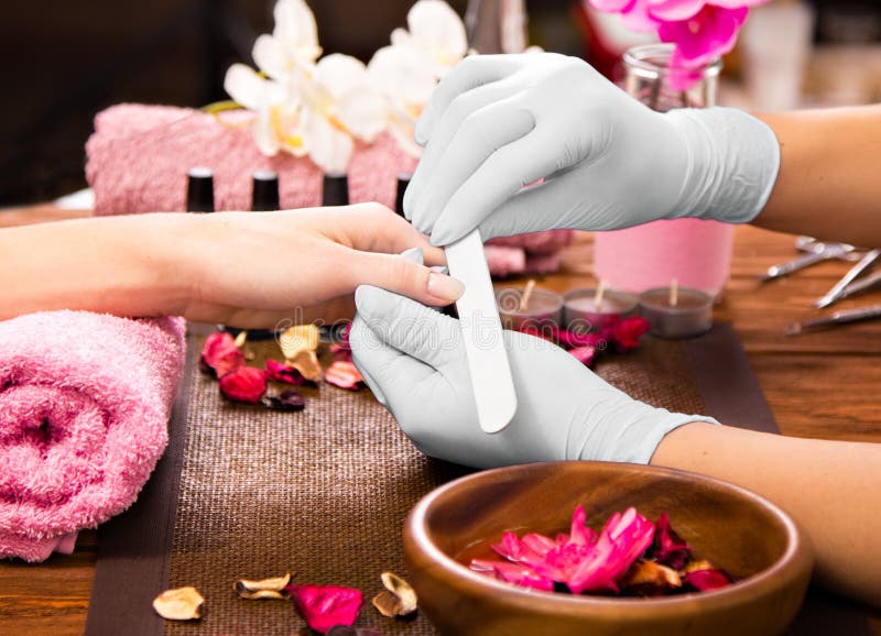 Cuidado do prego do dedo do close up pelo especialista do tratamento de mãos no salão de beleza
