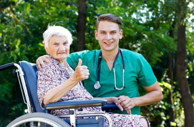 Young doctor helping a handicapped elderly woman. Young doctor helping a handicapped elderly woman