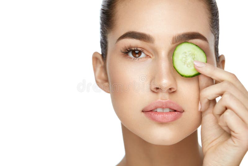 Cuidados com a pele do olho Mulher com composição natural usando o pepino foto de stock royalty free Cuidados com a pele do olho Mulher com composição natural usando o pepino foto de stock royalty free