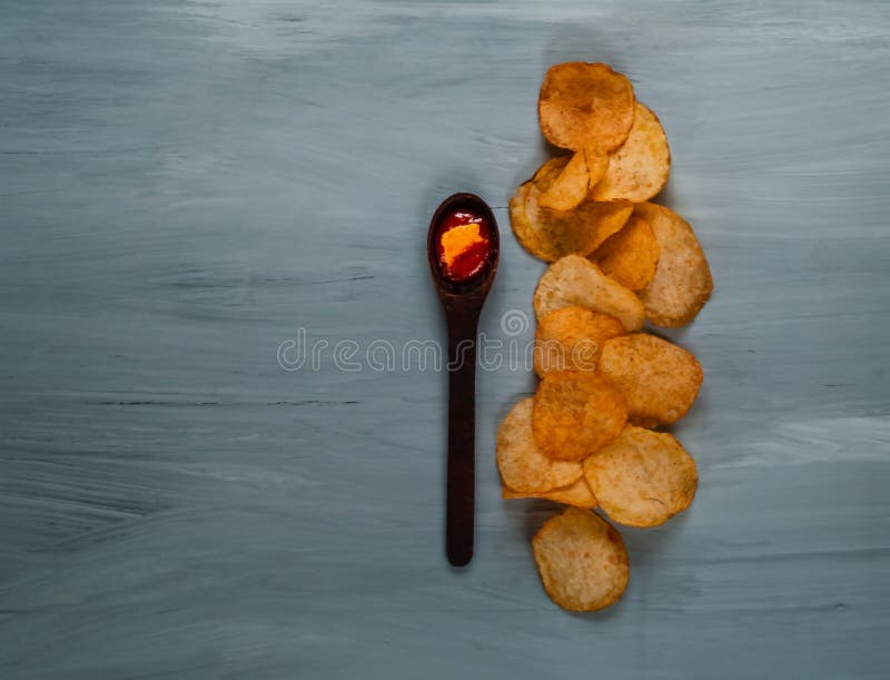 Cuillère en bois avec le ketchup et puces sur un fond en bois bleu, vue supérieure, l'espace pour le texte images libres de droits Cuillère en bois avec le ketchup et puces sur un fond en bois bleu, vue supérieure, l'espace pour le texte images libres de droits