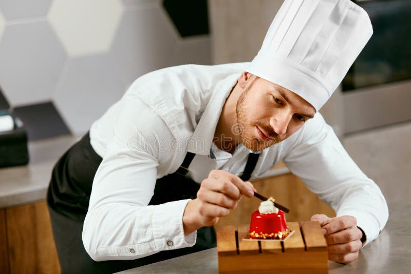 Cuisine masculine de Decorating Dessert In de cuisinier de pâtisserie