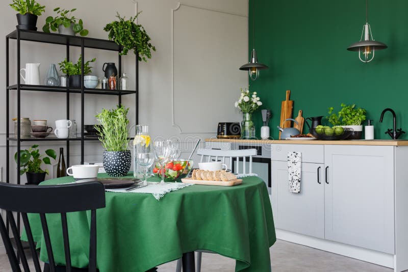 Trendy kitchen with dining table with green tablecloth set for romantic dinner concept photo. Trendy kitchen with dining table with green tablecloth set for romantic dinner concept photo