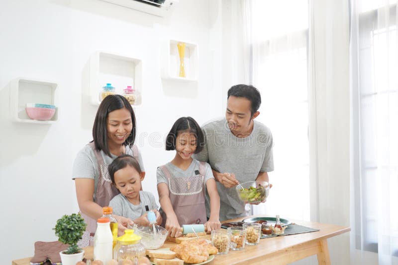 Cuisiniers heureux d'Asiatique de famille dans la cuisine image stock Cuisiniers heureux d'Asiatique de famille dans la cuisine image stock