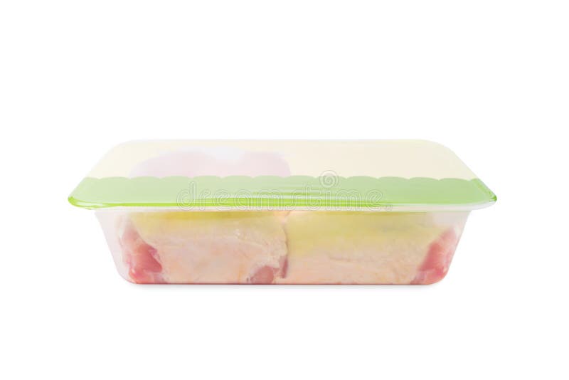 Chicken thigh meat in a tray for a supermarket.Transparent tray with meat inside on an isolated background.Side view.Raw chicken thigh with skin for cooking. Chicken thigh meat in a tray for a supermarket.Transparent tray with meat inside on an isolated background.Side view.Raw chicken thigh with skin for cooking.